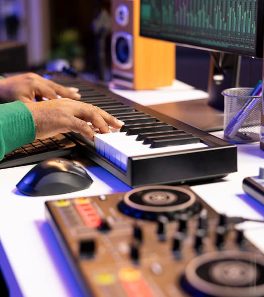 Hands on keys and production desk in the studio