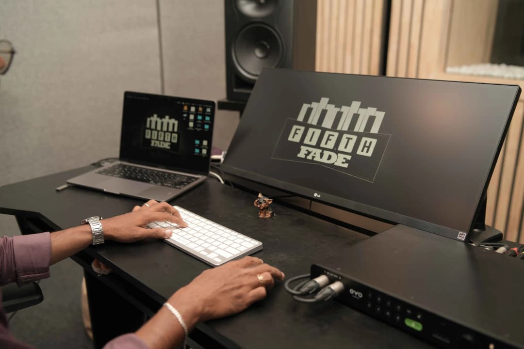 Hands playing a keyboard in a music studio